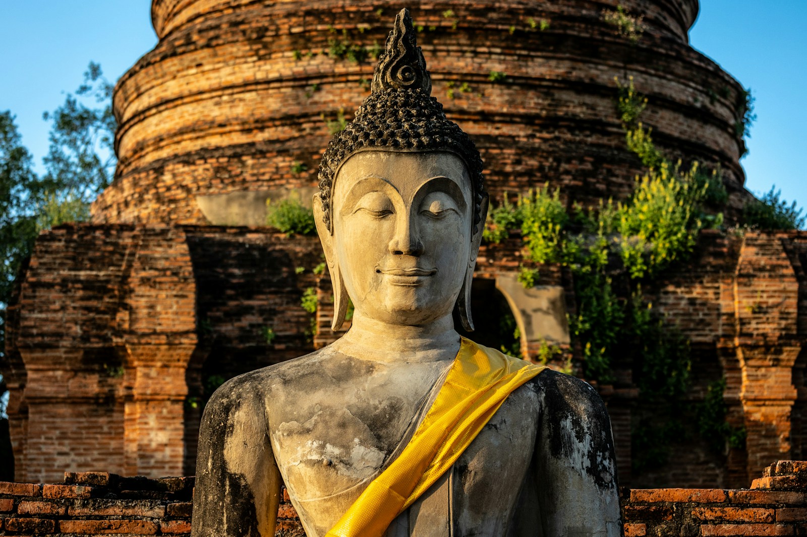 a large buddha statue sitting in front of a brick building